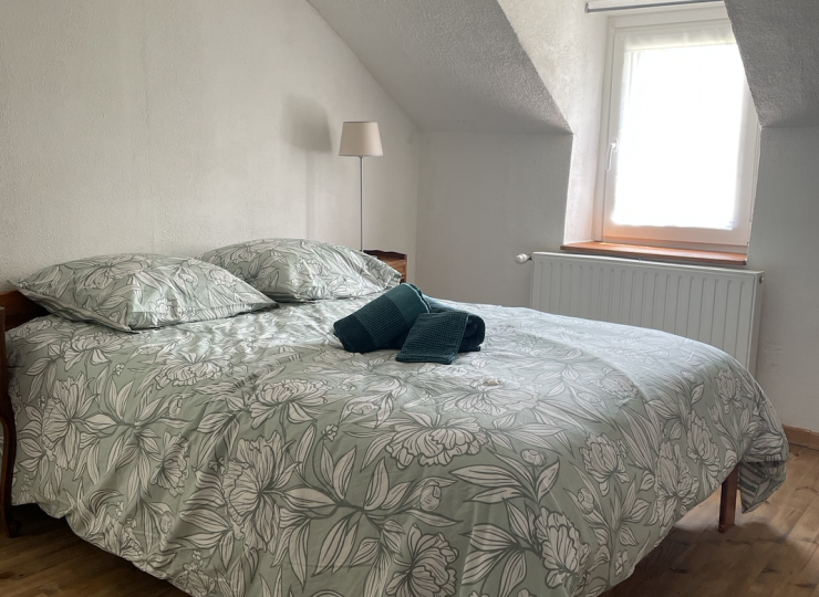 Chambre mansardée avec lit double et lumière naturelle