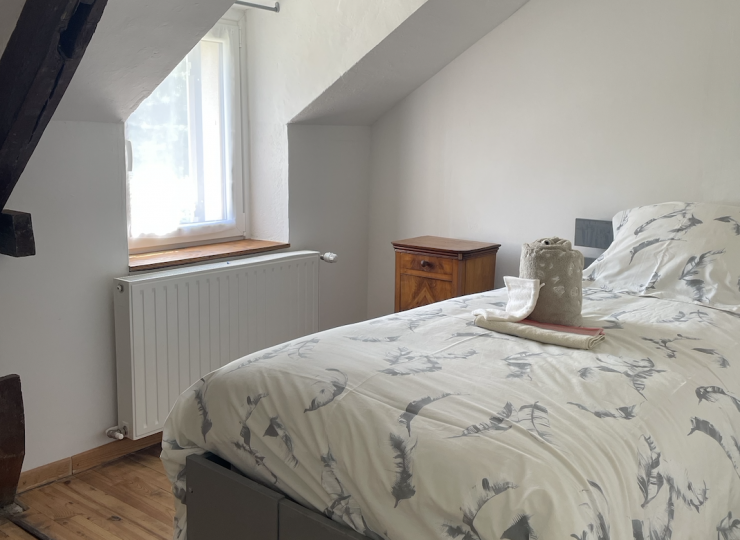Chambre individuelle avec lit simple et poutre ancienne